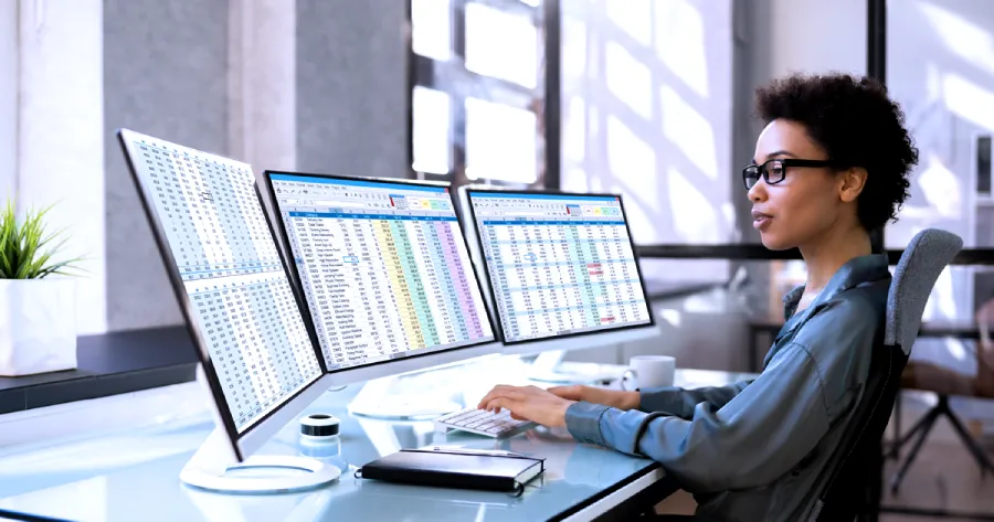 A woman is working on a desktop computer