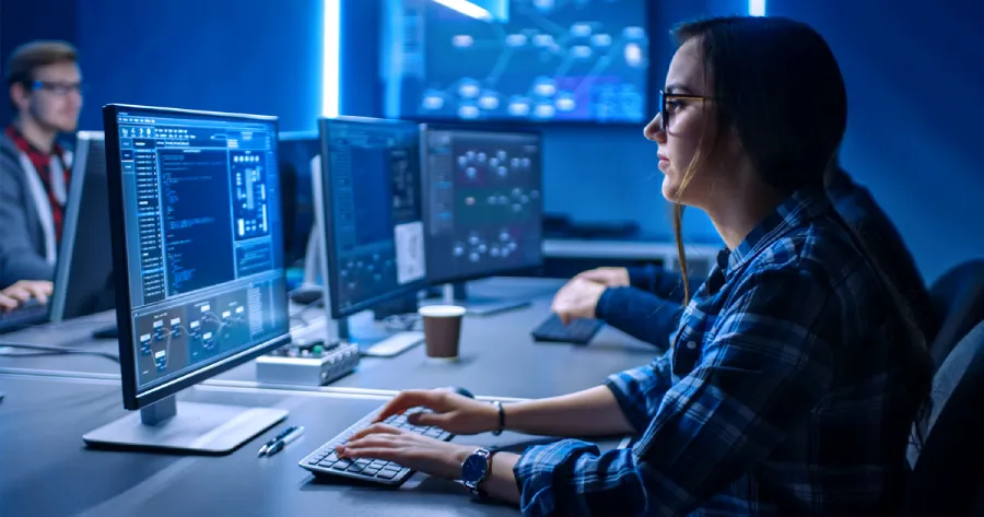  A woman sitting in front of a desktop computer. 