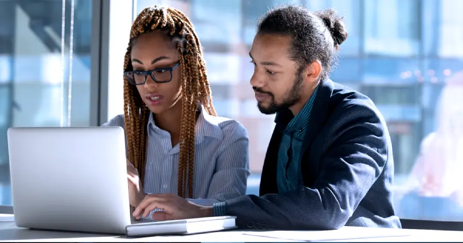 A man and a woman working together on a laptop. 