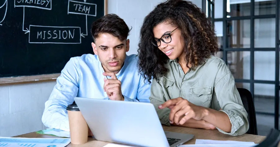 A man and a woman looking at a laptop screen. 