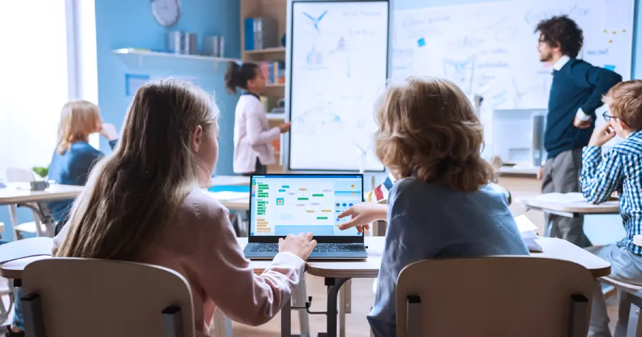 Students learning from a laptop in a classroom. 