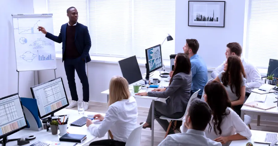 A corporate training in a classroom setting with computers 