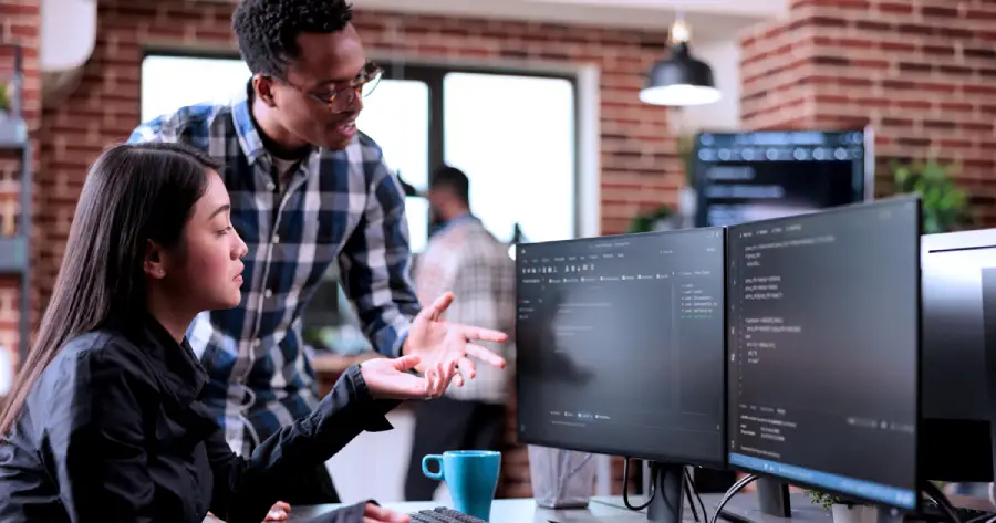 An image of a man and woman working together on a desktop computer. 