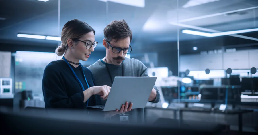 A man and a woman looking at a laptop screen. 