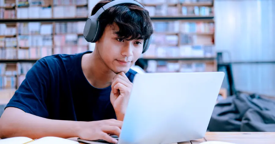 A high school male student studying on his laptop. 