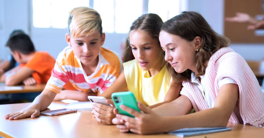 A group of students using a mobile learning platform on their smartphones in a class. 