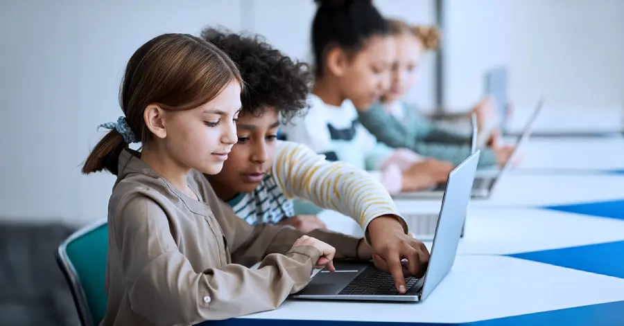 A boy and girl sitting together with a laptop studying via 360 Degree Learning