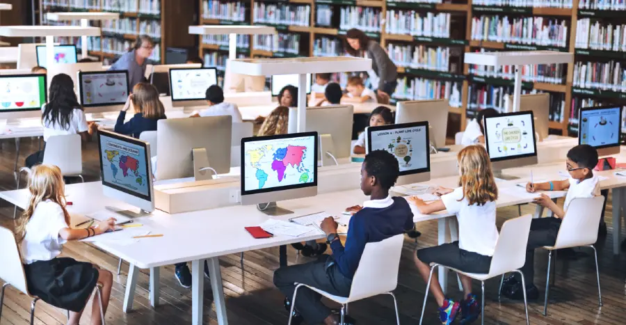 A group of students, engaged in gamification in education, sit at their individual computers playing learning games.