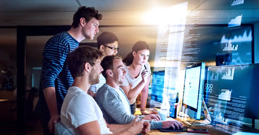 A group of people huddled around a computer with a virtual screen, brainstorming ideas for their latest future education technology project. 