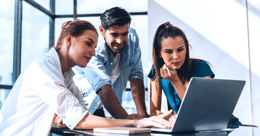 Group of diverse professional people pointing at a laptop displaying a web accessibility audit report. 