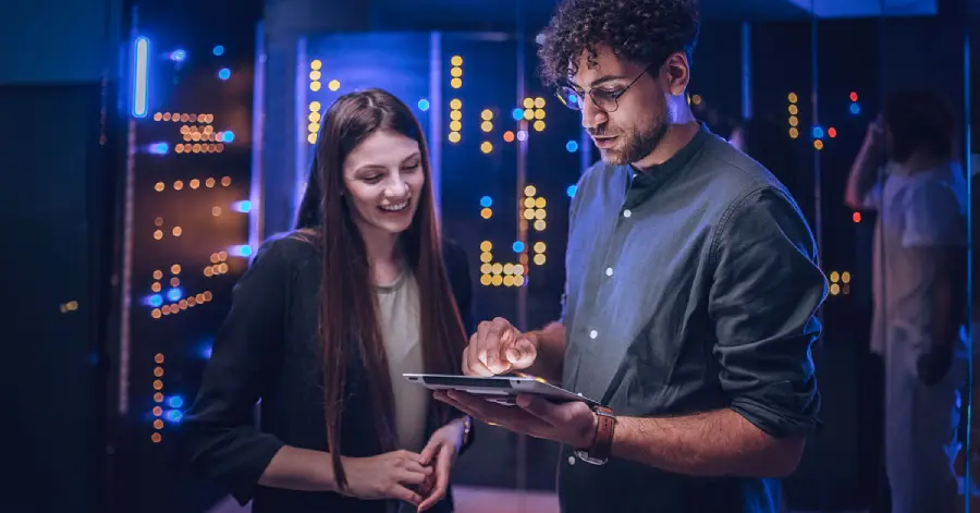 Male and female maintenance engineers examining data on AI Cloud on a digital tablet together. 