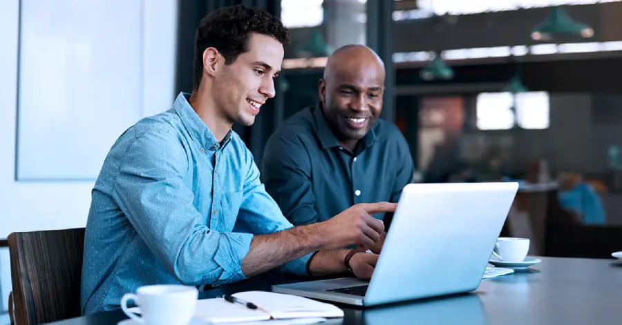 A group of two multiracial people learning together with a laptop. 