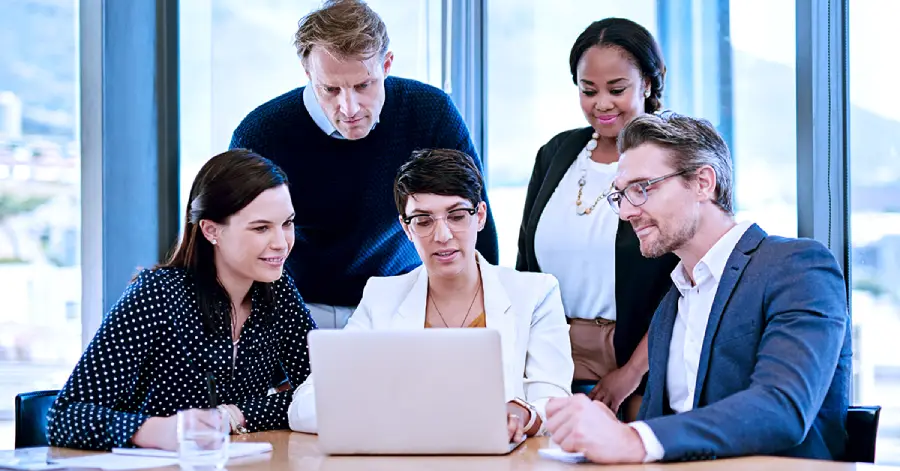 A multiracial group of leaders discussing how the integration of AI in a learning platform can lead to efficient career mobility for employees.